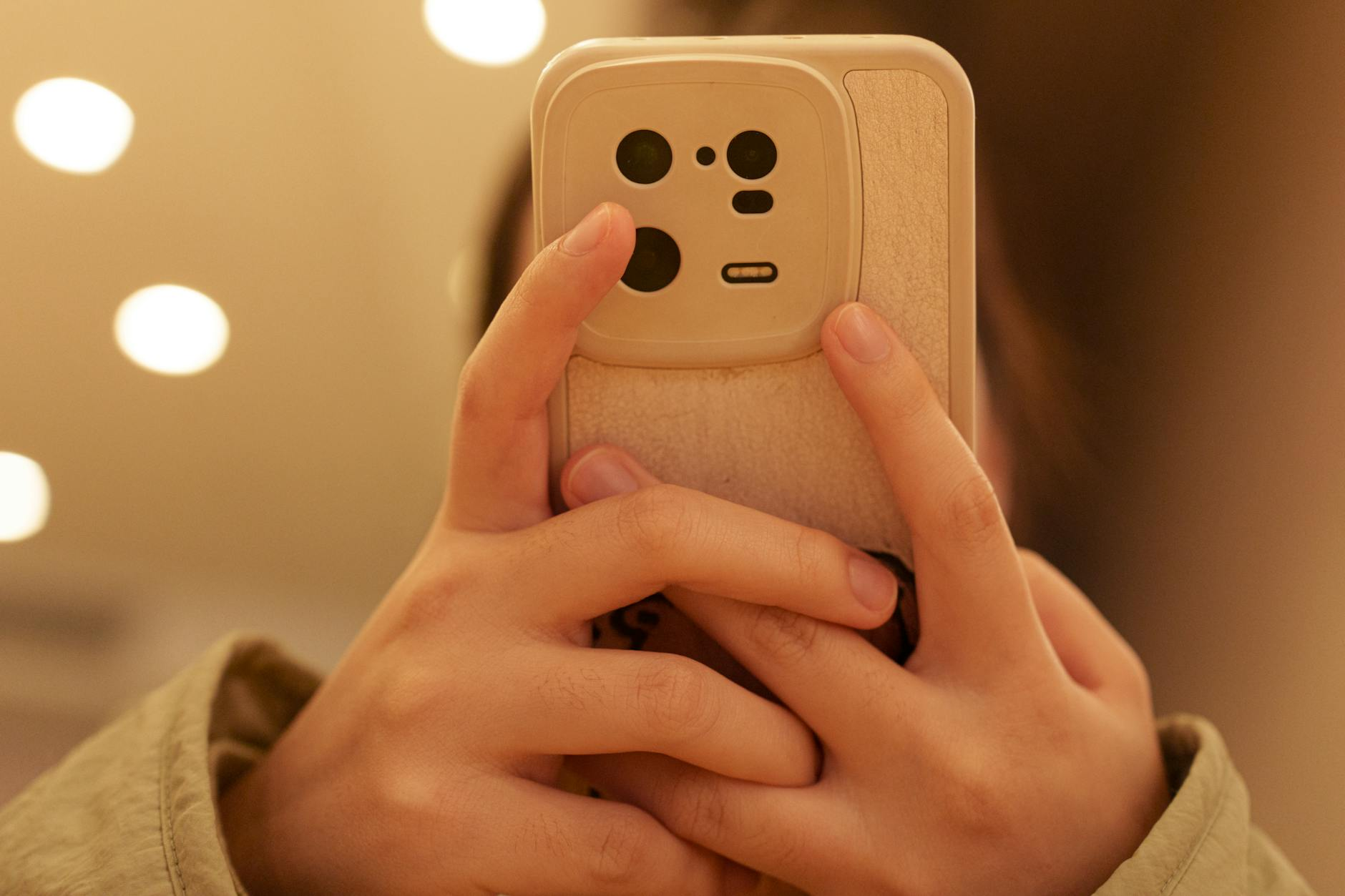 close up of hands holding smartphone indoors